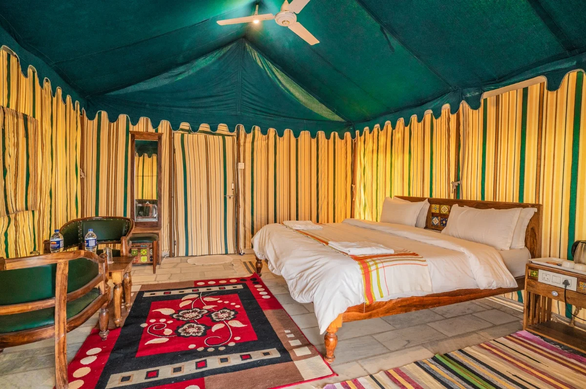 Interior of a Swiss tent with beds and lanterns